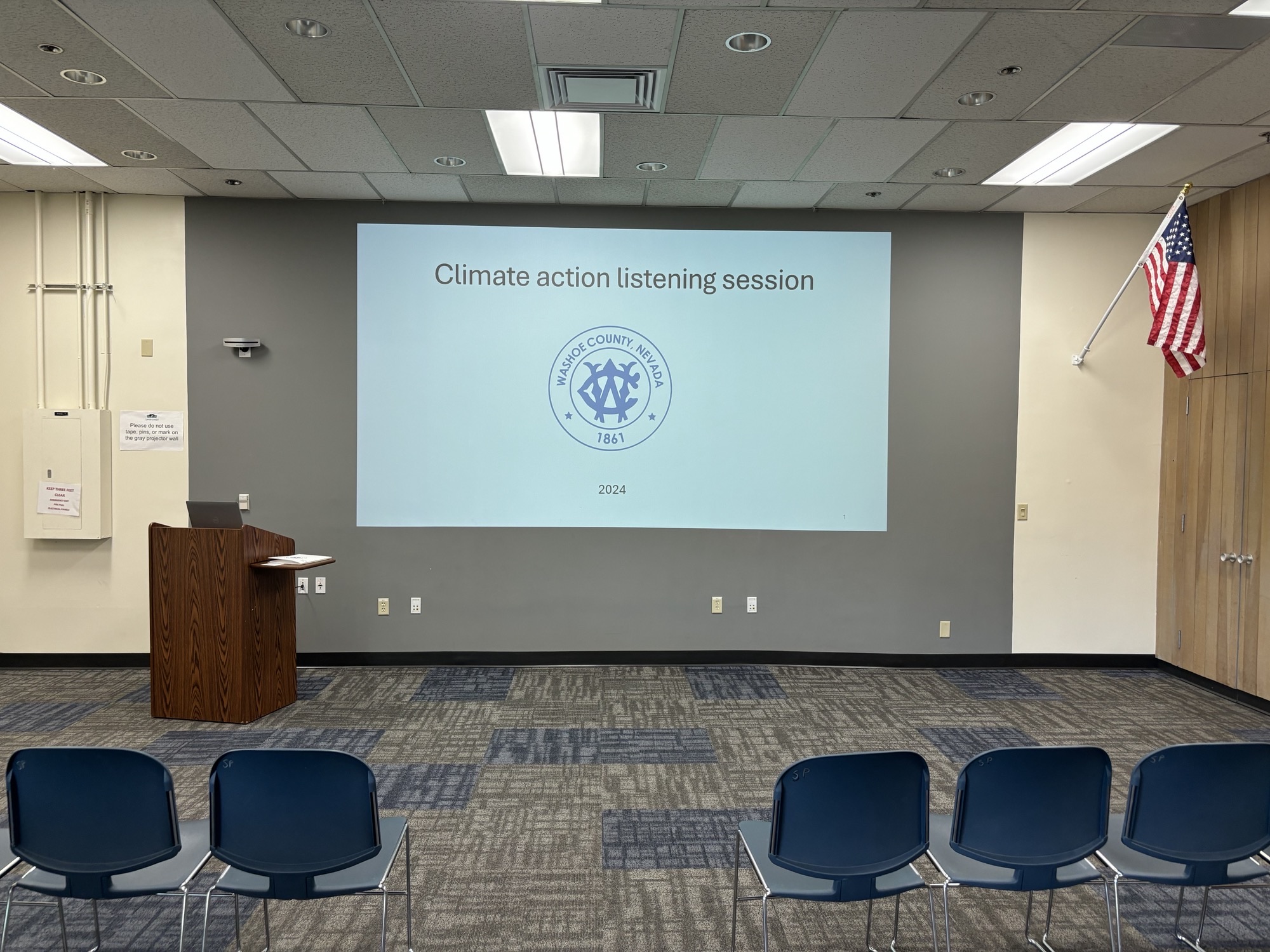 Chairs face a lectern next to a projection of a CAP presentation